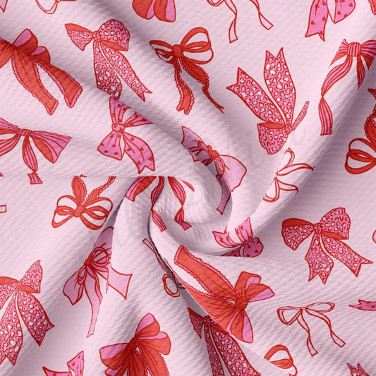 a close up of a pink fabric with bows on it