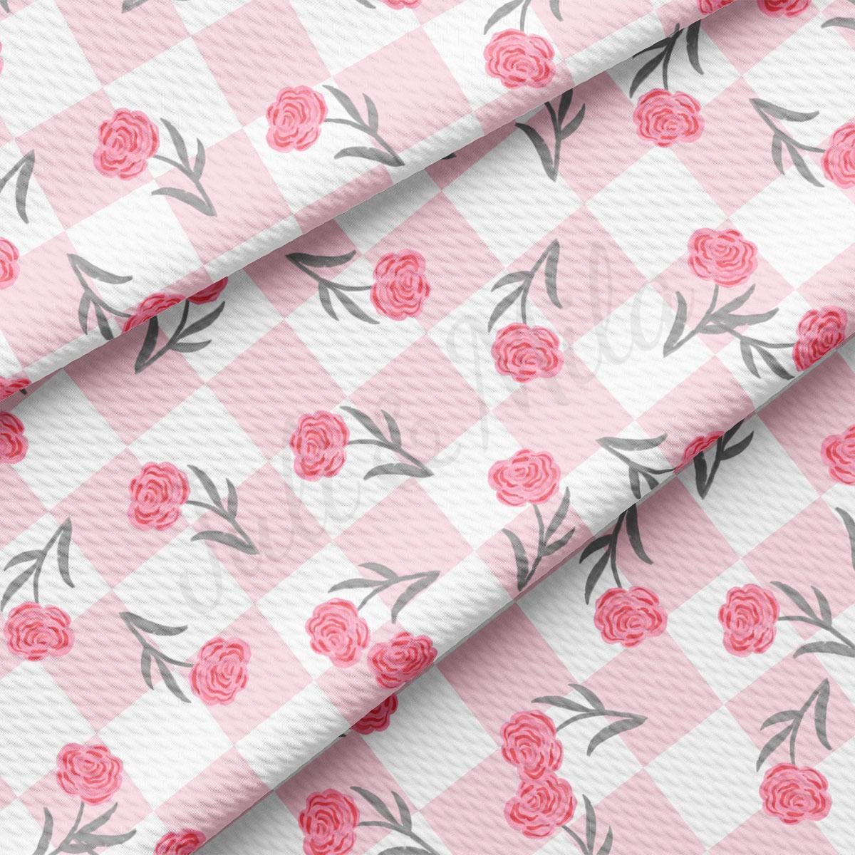 a pink and white checkered fabric with roses on it