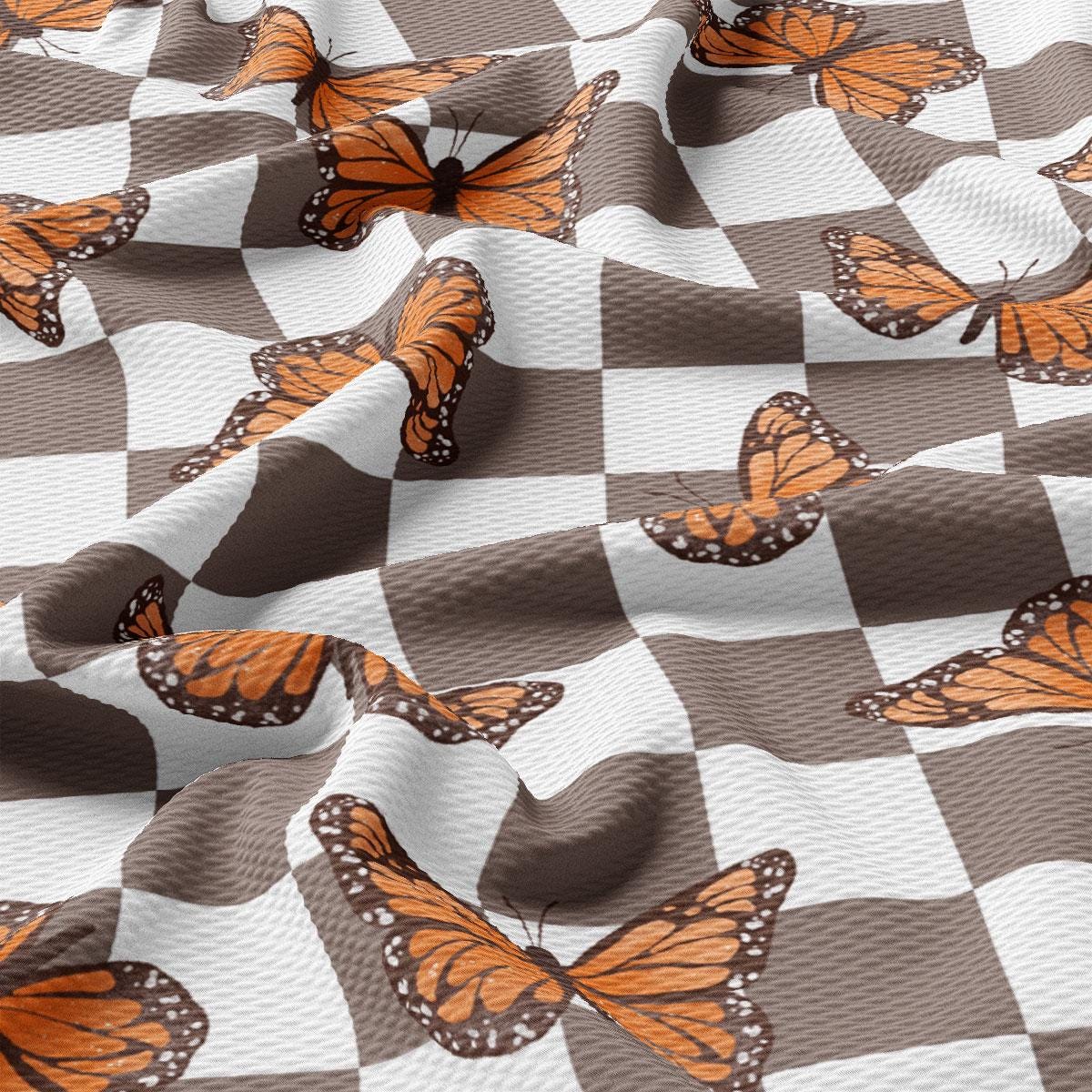 a checkered fabric with orange butterflies on it