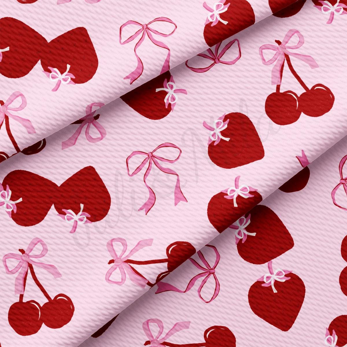 a pink and red fabric with cherries on it