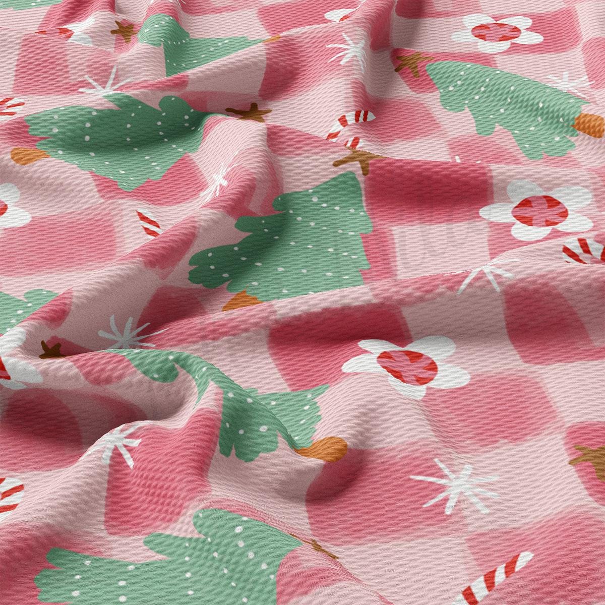 a pink and green checkered fabric with christmas trees on it