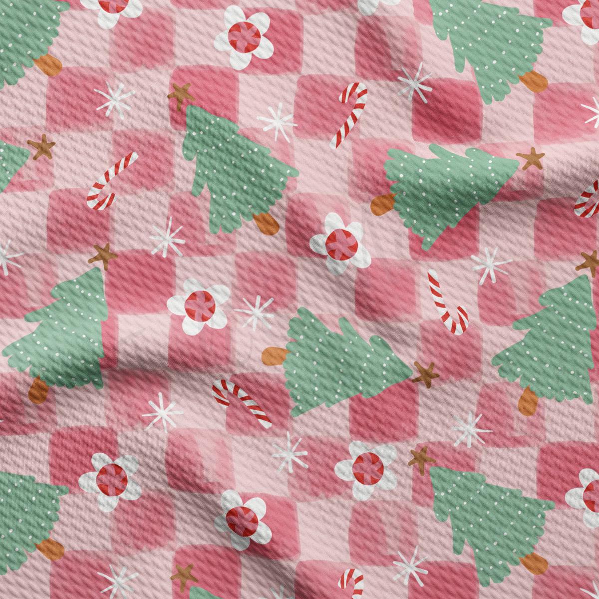 a pink and green checkered fabric with christmas trees on it