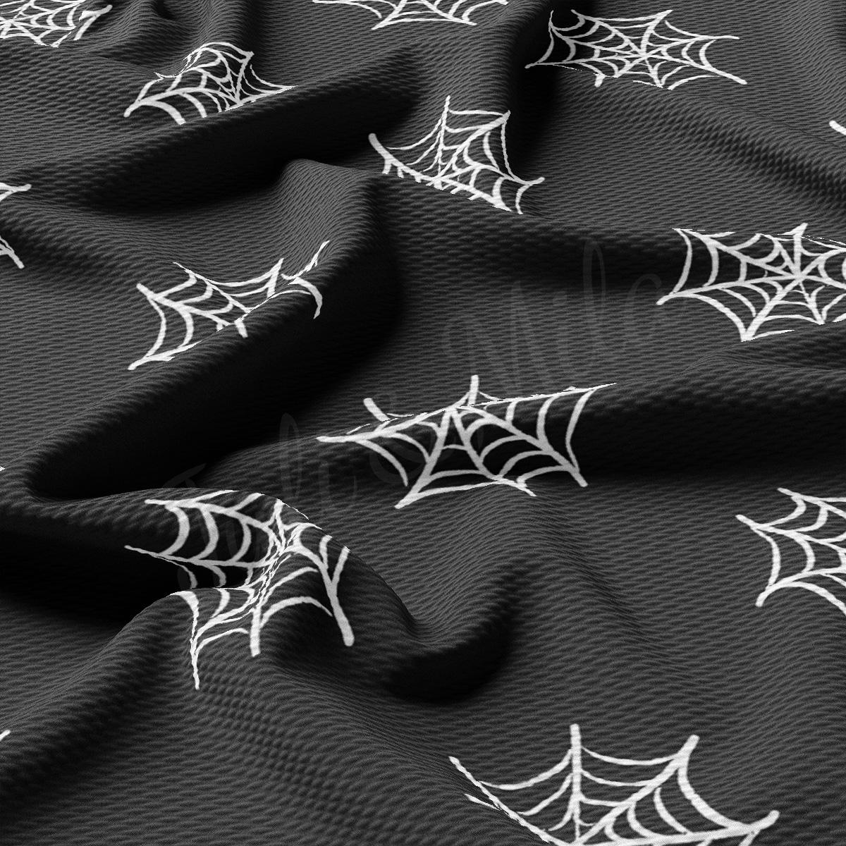 a black fabric with white spider webs on it