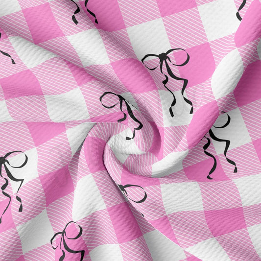 a pink and white checkered fabric with black figures on it