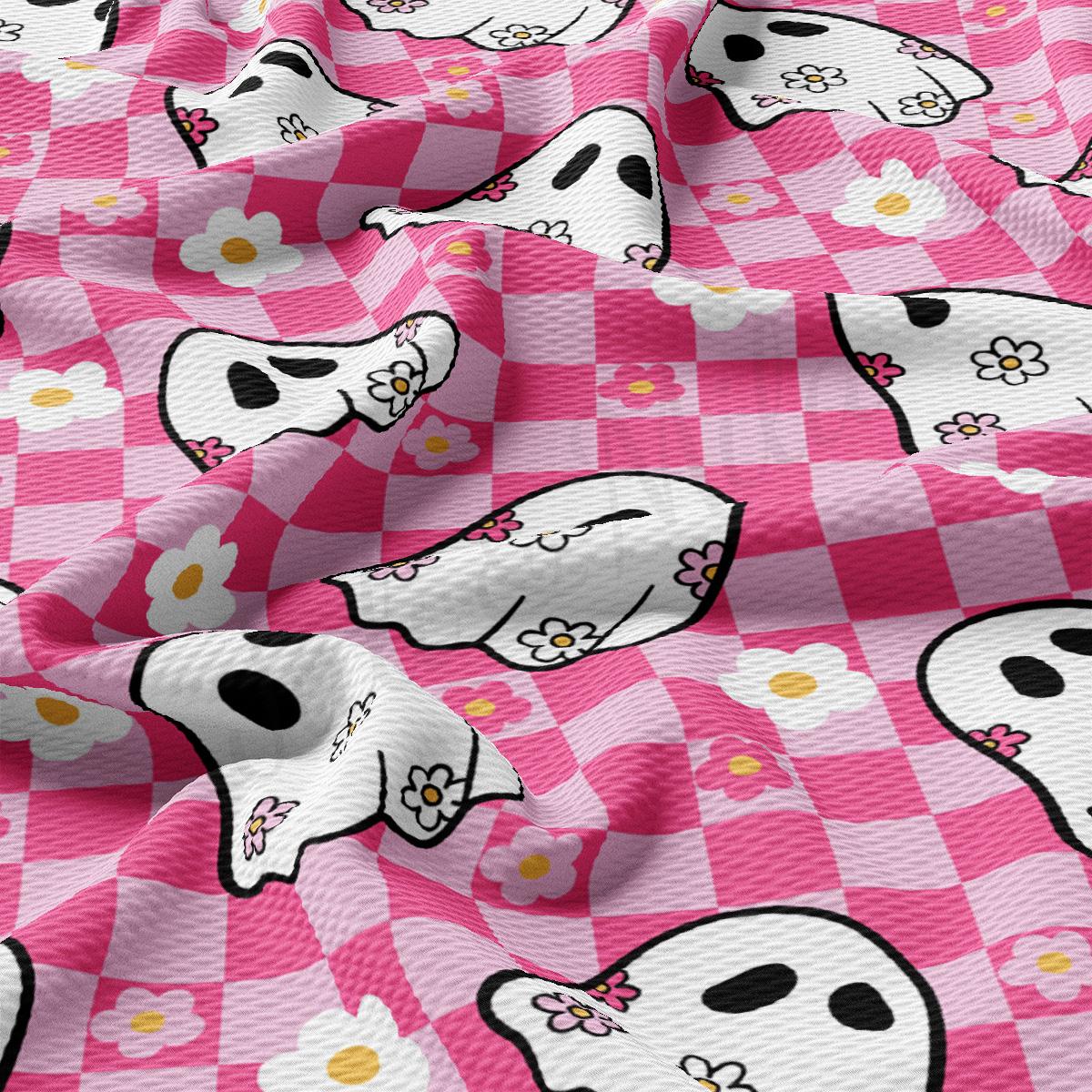 a pink checkered fabric with skulls and flowers on it