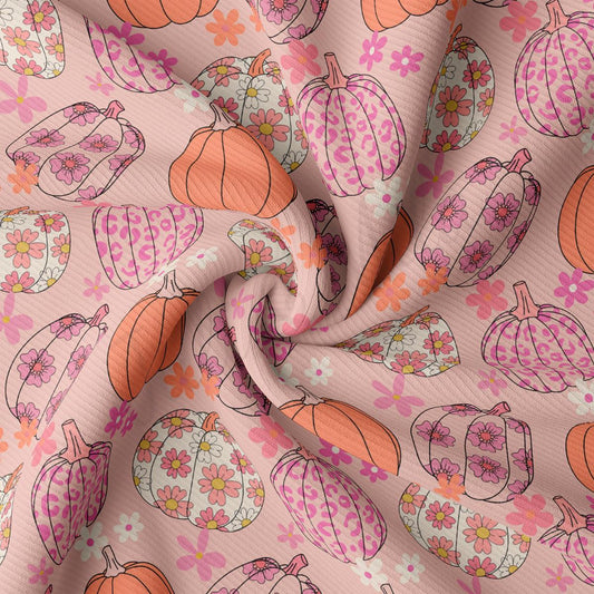 a pink and orange flowered fabric with pumpkins on it