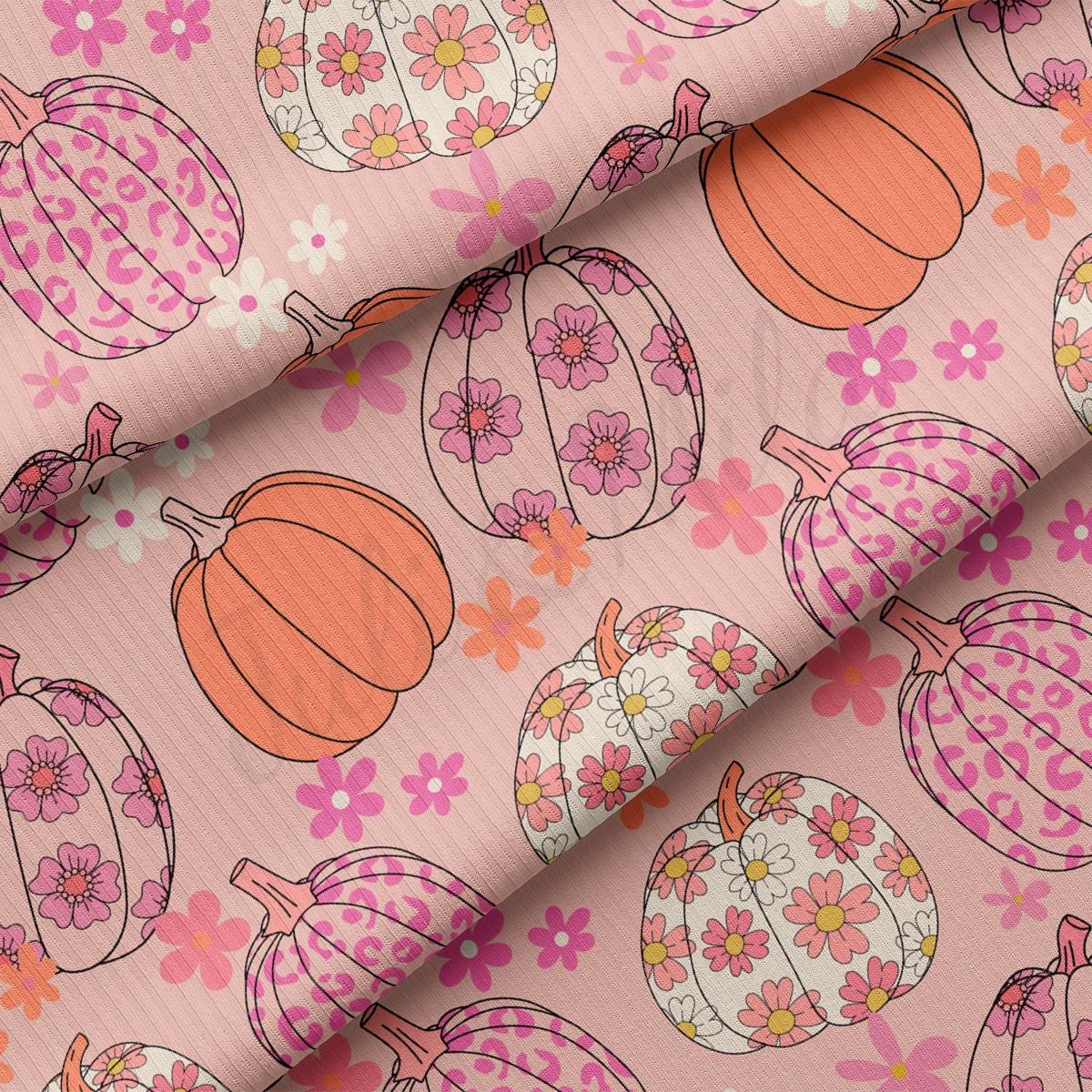 a close up of a pink fabric with flowers and pumpkins on it