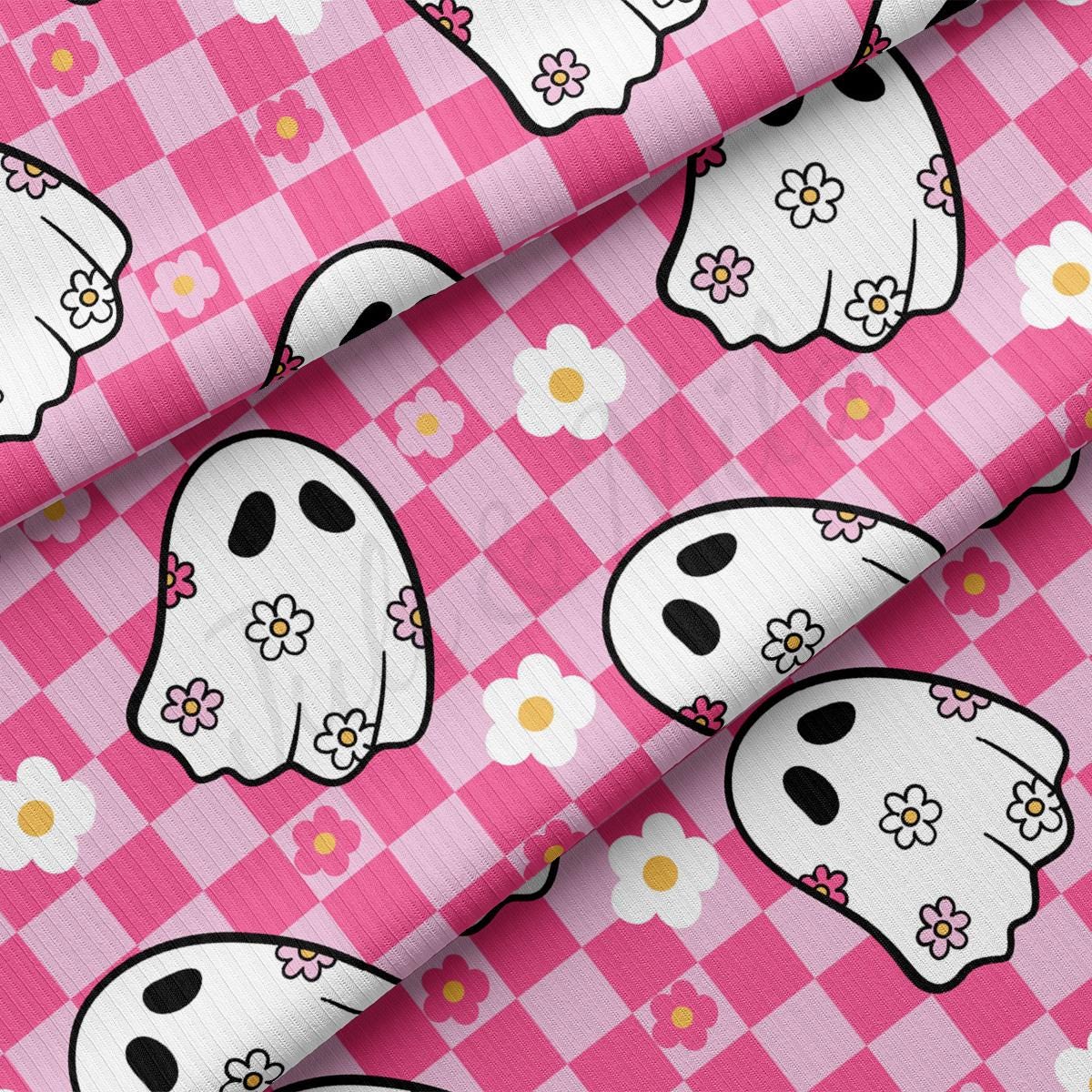 a pink and white checkered fabric with a ghost face on it