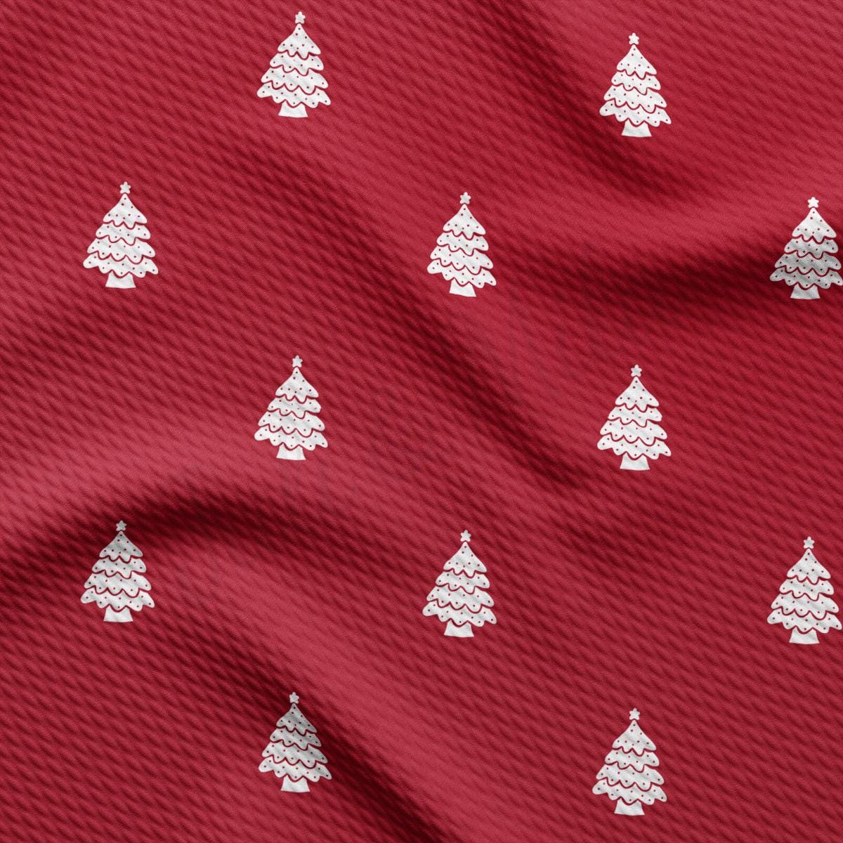 a red fabric with white christmas trees on it