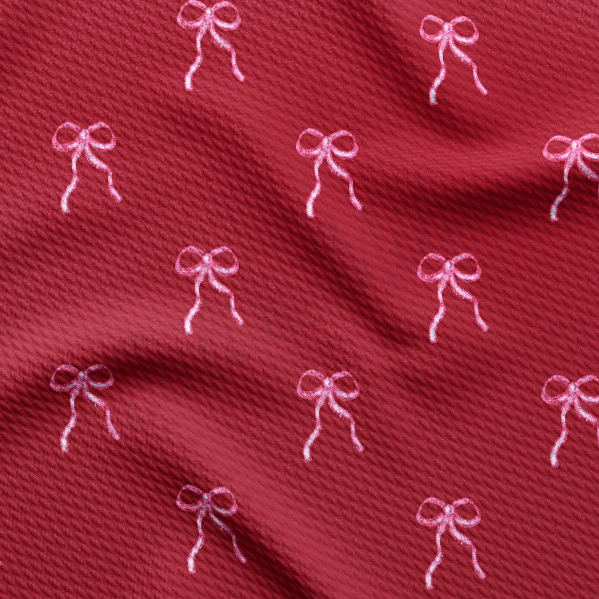 a close up of a red fabric with pink bows on it