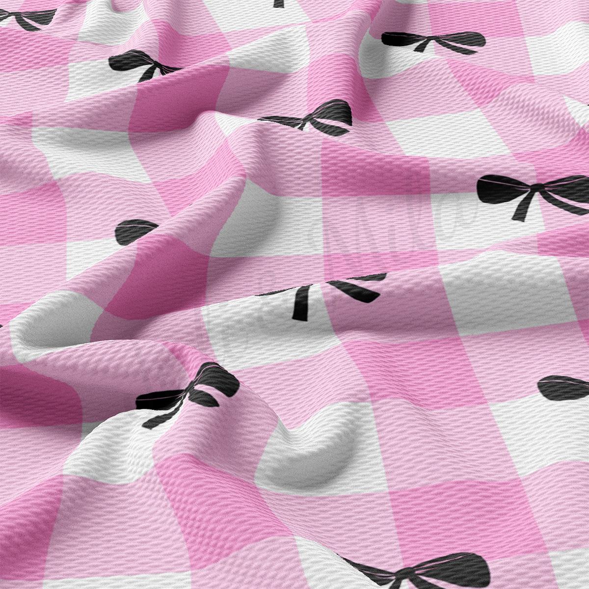 a pink and white checkered fabric with black bows