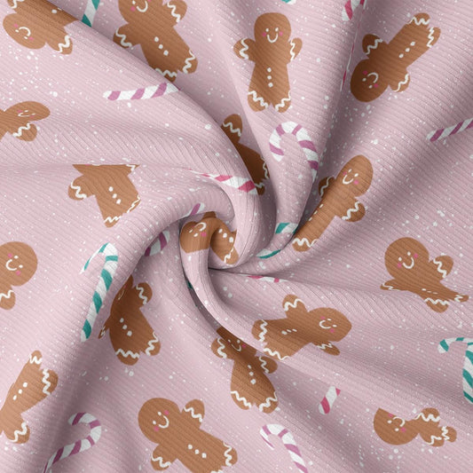 a pink fabric with gingerbreads and candy canes on it