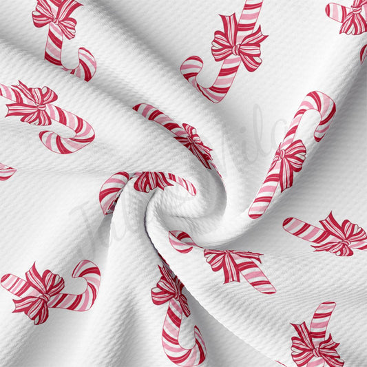 a white fabric with red and white candy canes on it