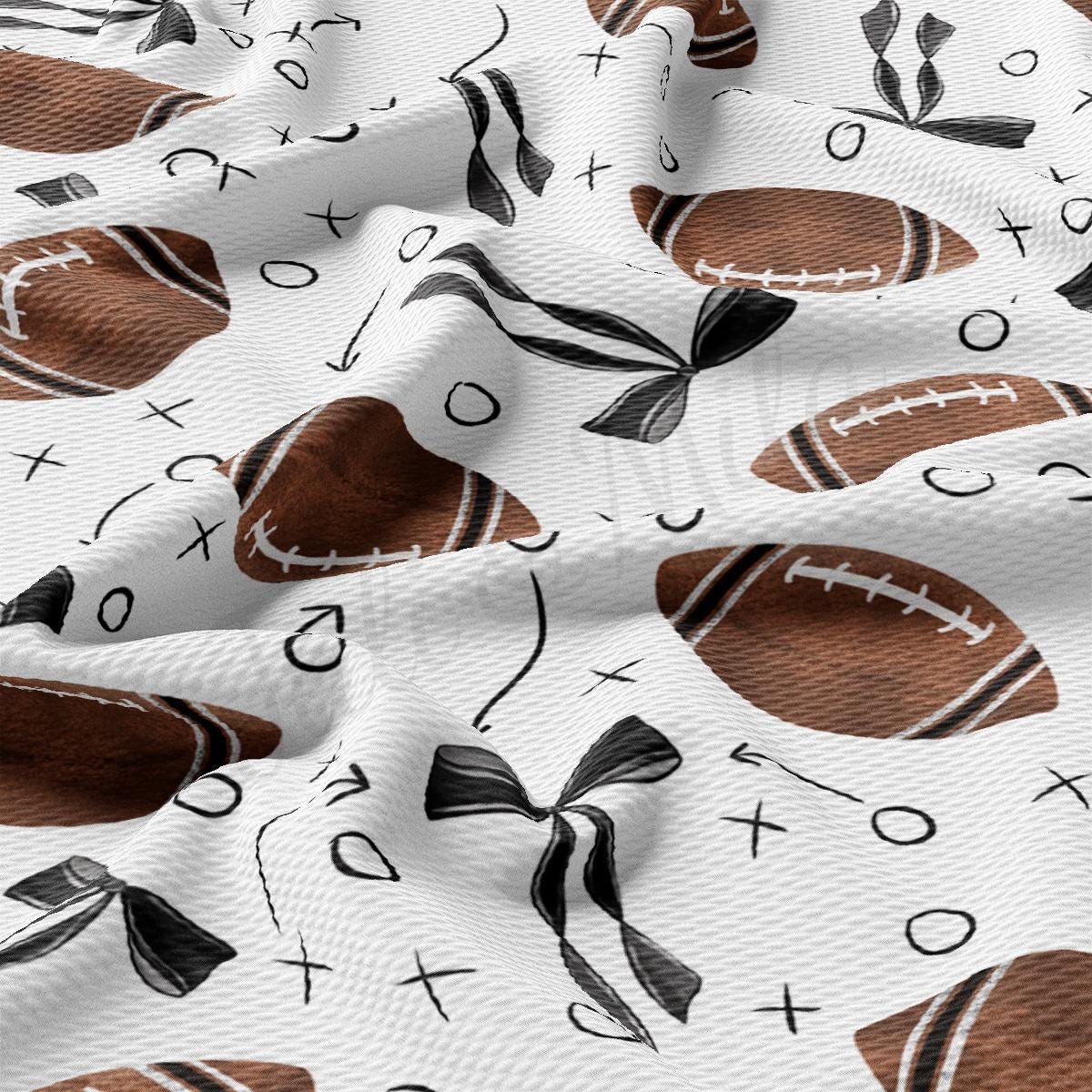 a white fabric with brown and black footballs on it